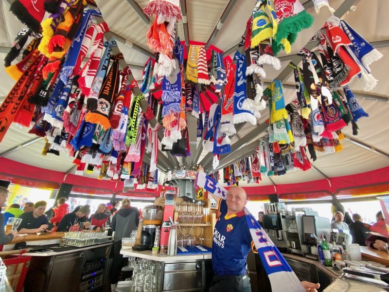 Range of football scarves from different teams with PlanetSKI editor sporting posing with one